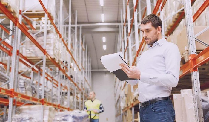 Image of man holding clipboard in warehouse