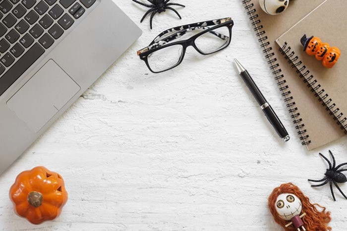 Overhead Halloween image of laptop and glasses