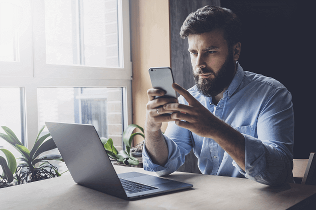 Man on mobile phone with laptop