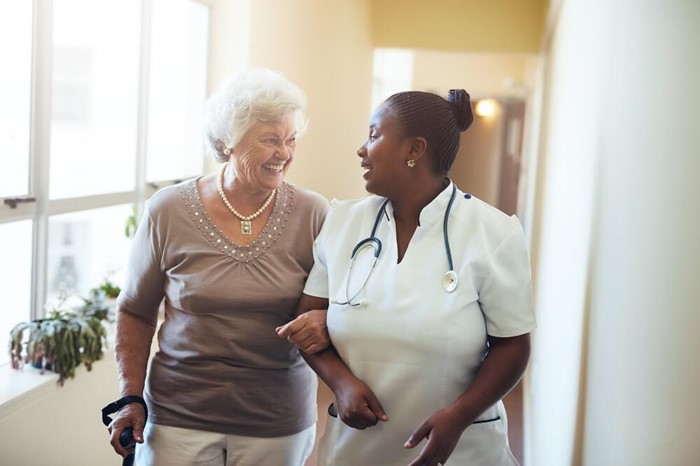 nurse walks with elderly lady