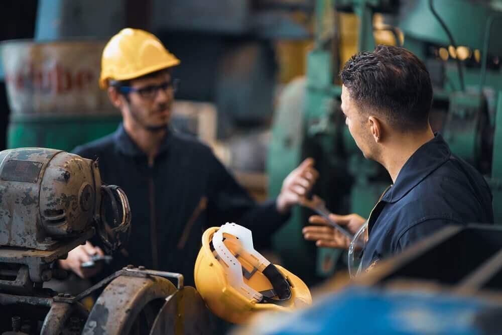 Workers with hard hats in conversation