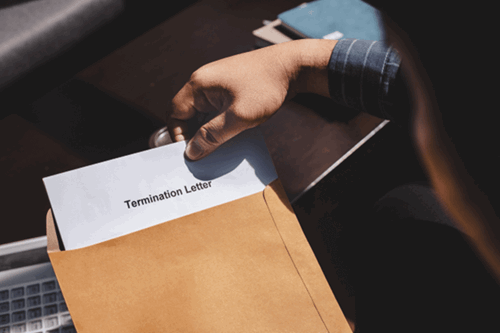an employee opening a employment termination letter, with their notice period stated.