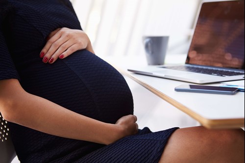 a lady holding her bump as she nears her expected week, ready to take ordinary maternity leave and pay.