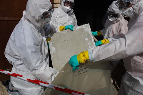Substances hazardous to health like asbestos is a dangerous dust being put in a bag to be exposed of safely.