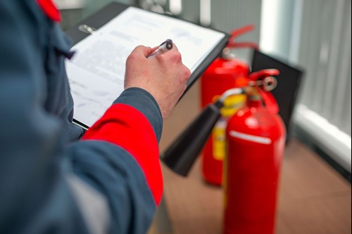 fire risk assessors carrying out fire safety risk assessment and looking at fire extinguishers.