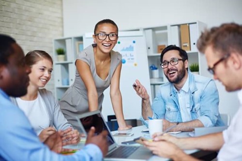 Employees sat round a table enjoying good employee health and wellbeing support.