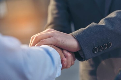 Two people shaking hands supporting employees through short term counselling