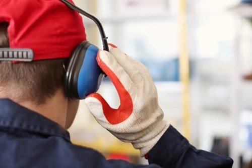 Competent person testing ear defenders to determine noise risks in line with noise at work regulations legal limits.