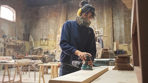 employee wearing ear defenders due to excessive noise level identified by a noise risk assessment.