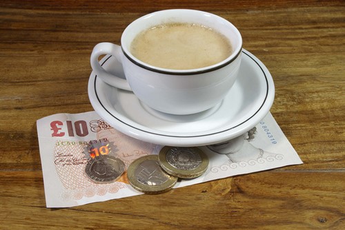 a cup of tea with some money under it