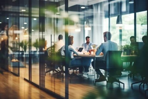 workers sat round a table on laptops