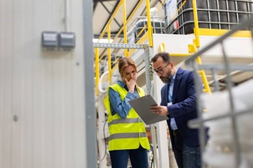 an employee being shown a clip board at work with something wrong on it - suggesting they haven't followed the proper procedure.