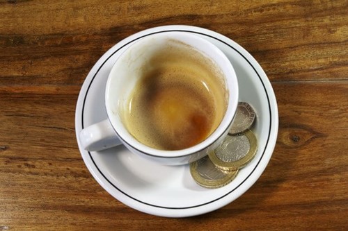 A tip left on the side of a cup and saucer in a coffee shop.