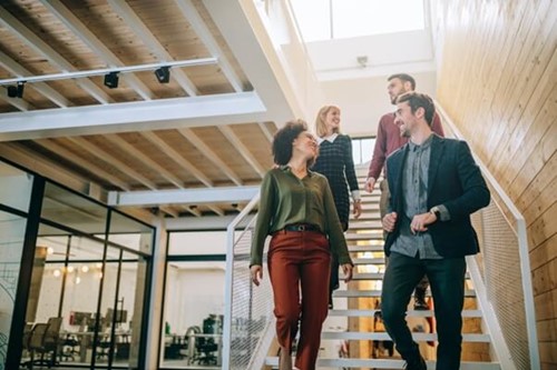 motivated employees walking down some stairs providing a positive company culture