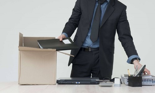 An employee eligible for statutory redundancy  clearing their desk after being made redundant .