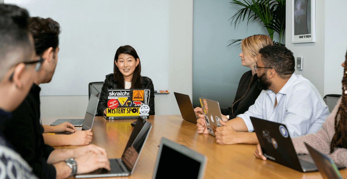 people sitting at board room office with laptop computers