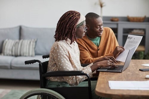 man providing assistance to a disabled woman