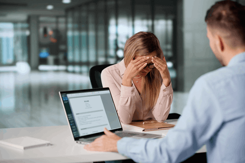 employee having disciplinary meeting with manager at desk