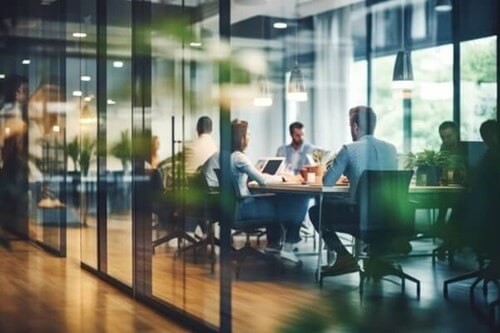 Workers sat round a table on laptops.