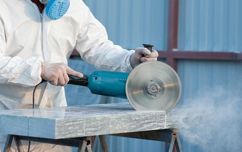 A worker dry cutting engineered stone which has been banned by the HSE.